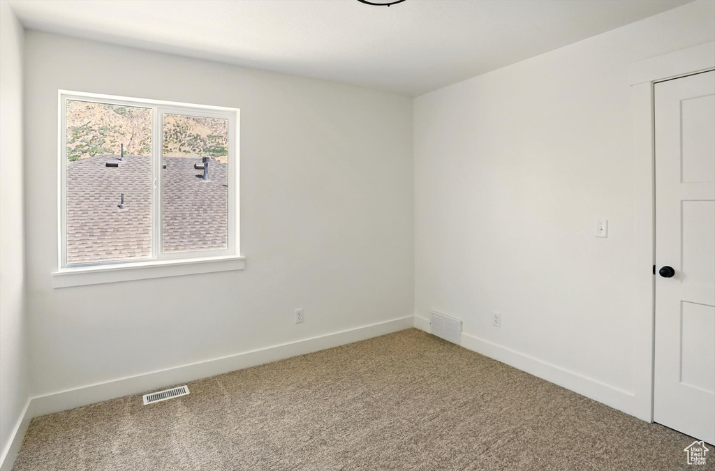 Carpeted empty room with baseboards