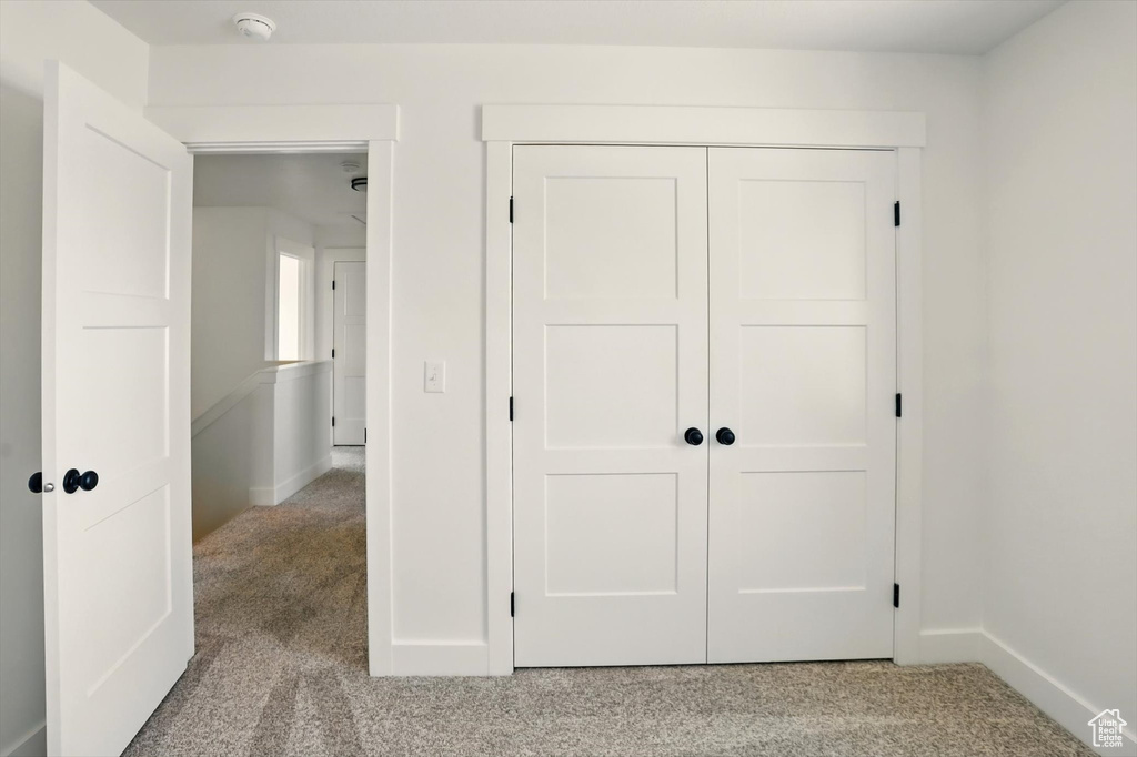 Unfurnished bedroom with carpet flooring and a closet