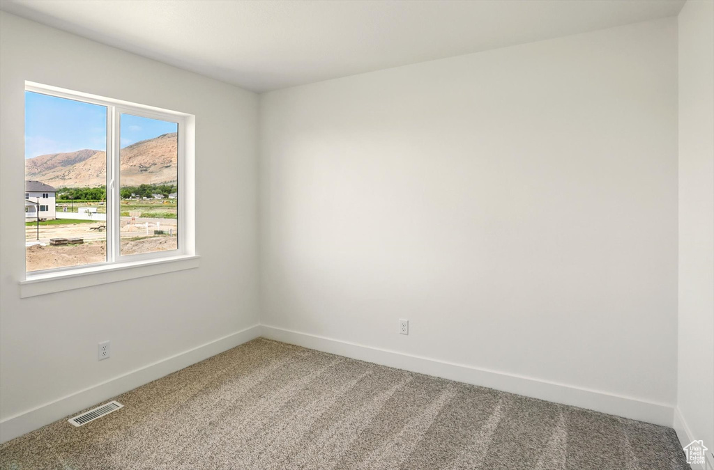 Empty room with carpet flooring and a mountain view