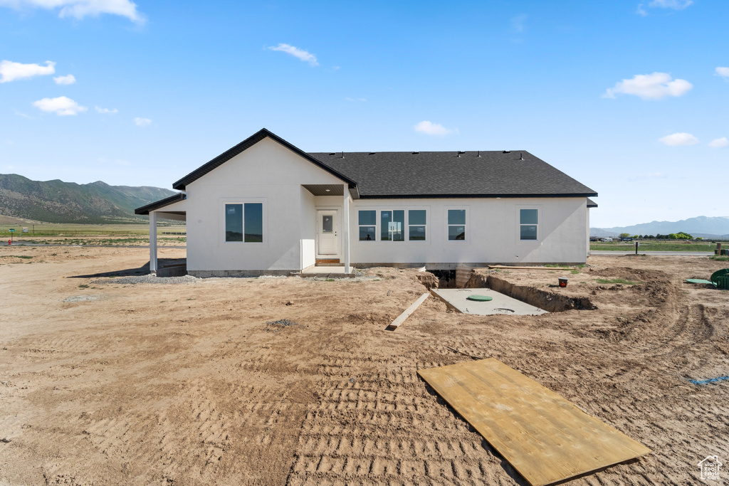 Rear view of house with a mountain view and roof with shingles