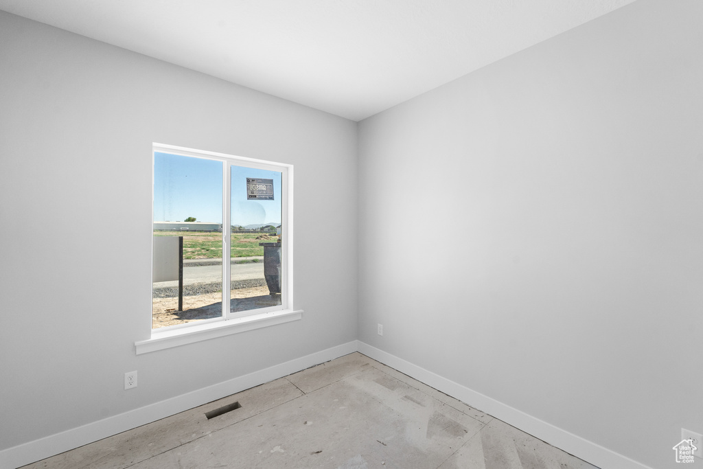 Empty room with baseboards and concrete floors