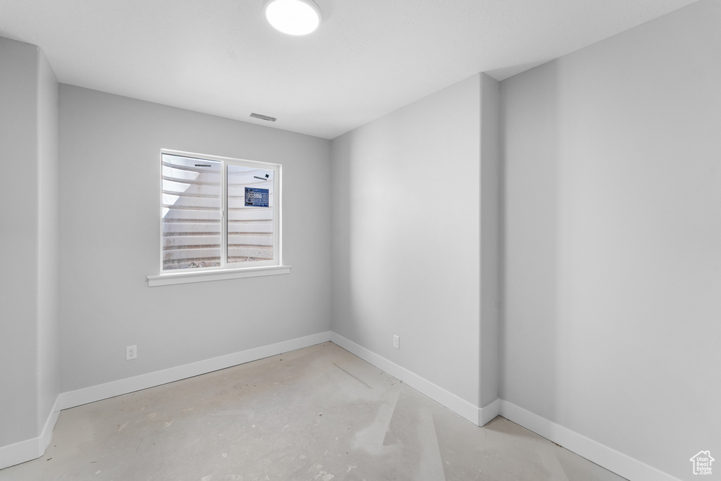 Empty room with concrete floors and baseboards