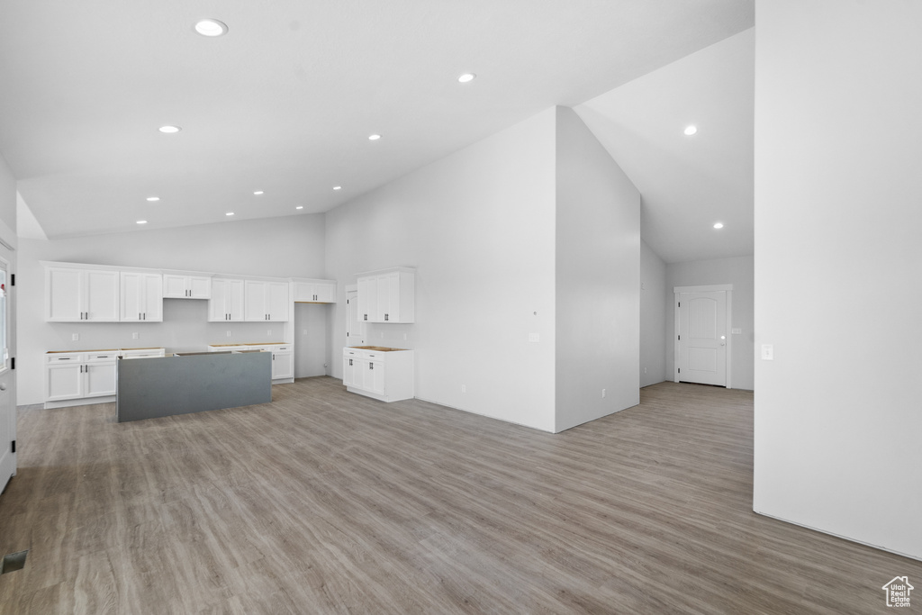 Unfurnished living room featuring recessed lighting, light wood-style flooring, and high vaulted ceiling