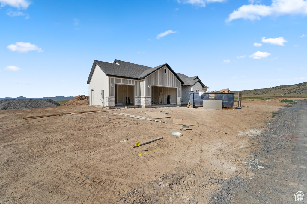 View of front of home featuring board and batten siding, a shingled roof, and a mountain view
