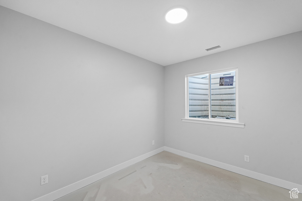 Spare room with concrete flooring and baseboards