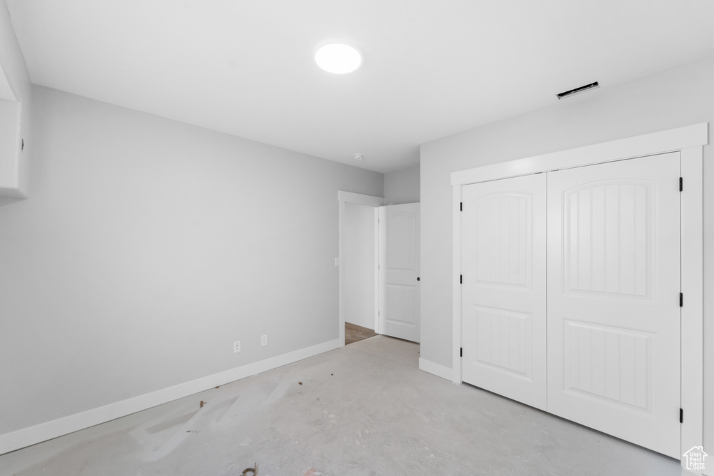 Unfurnished bedroom featuring a closet and unfinished concrete floors