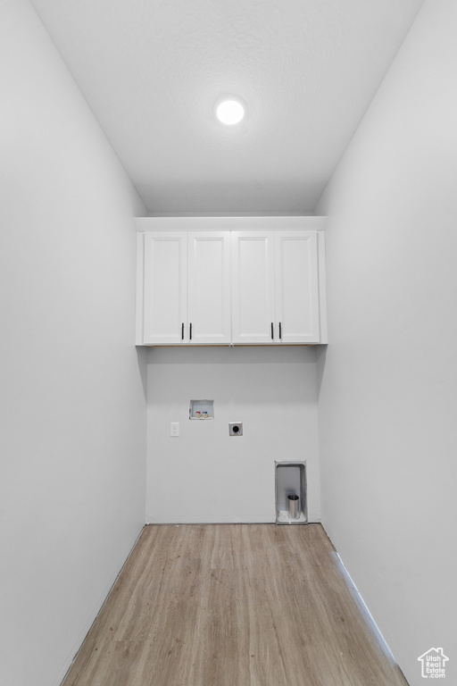 Laundry room with cabinet space, electric dryer hookup, light wood-style flooring, and washer hookup