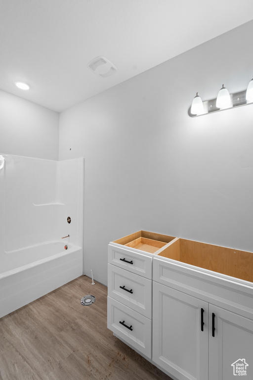 Bathroom featuring wood finished floors and tub / shower combination