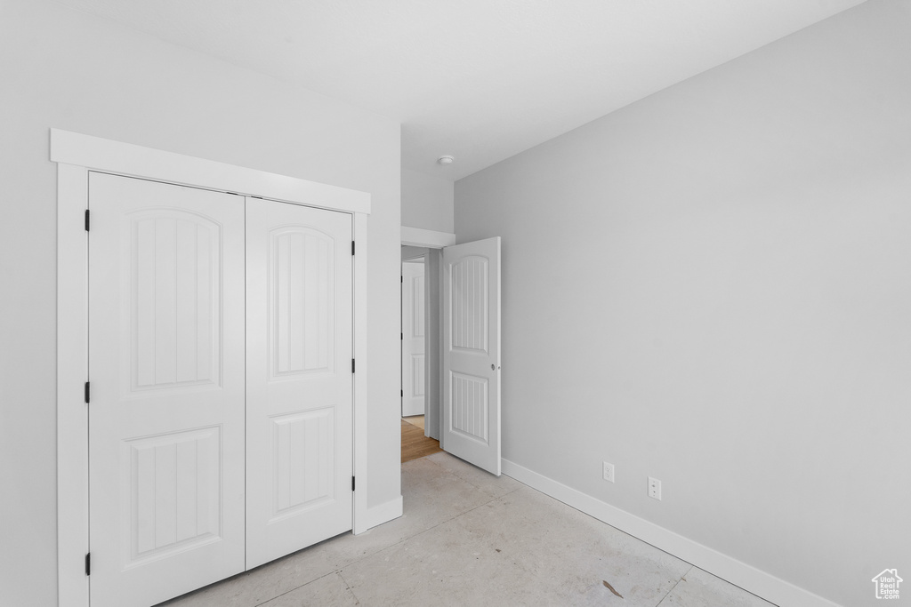Unfurnished bedroom featuring a closet and concrete flooring