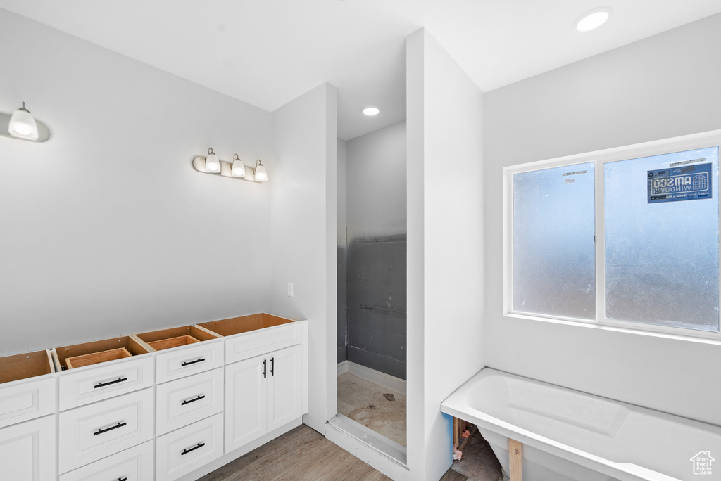 Bathroom featuring a garden tub and wood finished floors