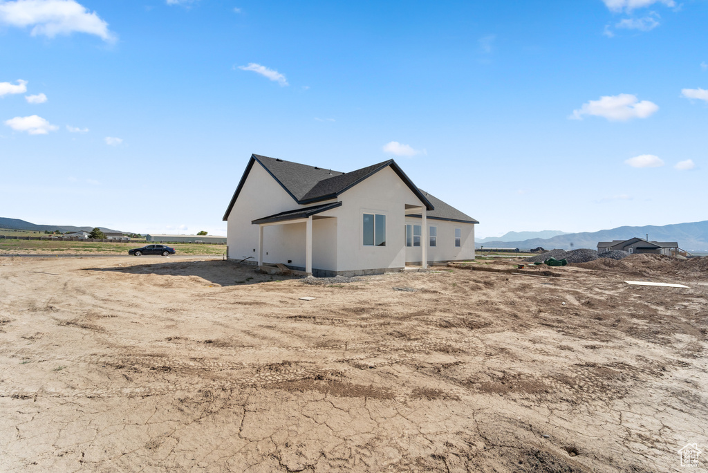 View of side of home featuring a mountain view and stucco siding