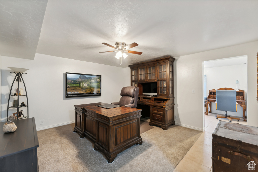 Office featuring a ceiling fan and light tile patterned floors
