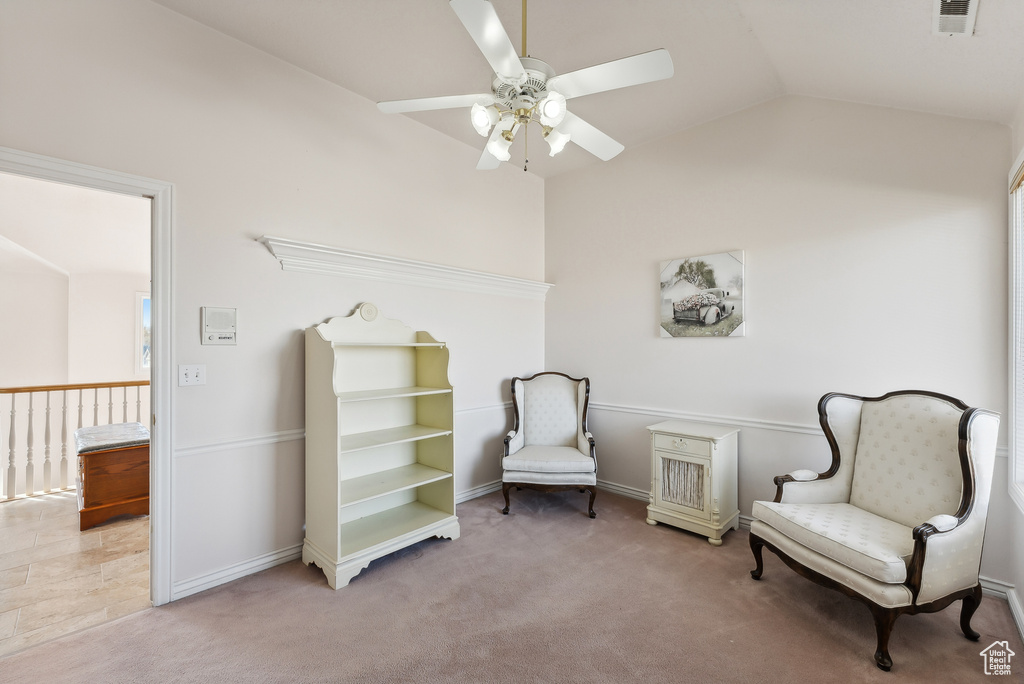 Sitting room with ceiling fan, lofted ceiling, and carpet floors