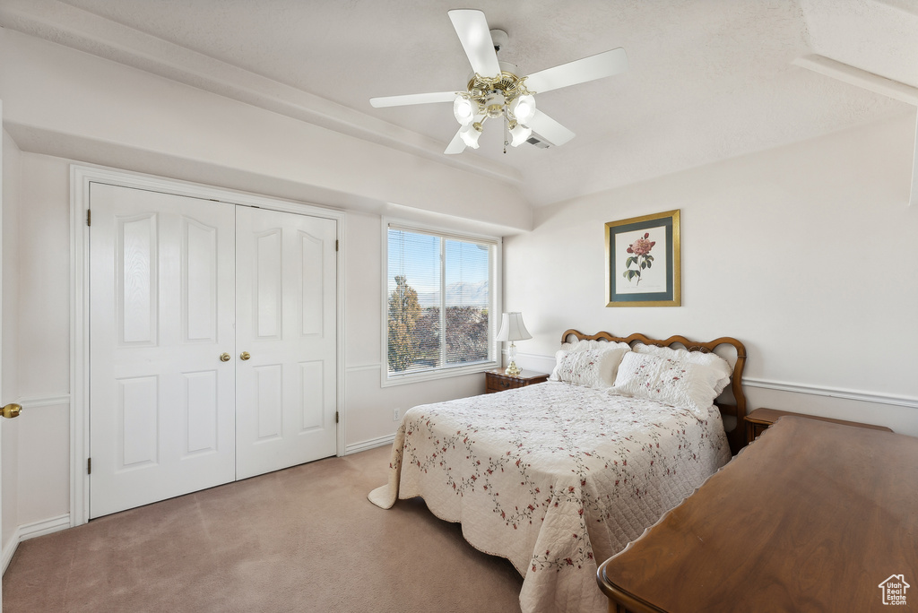 Bedroom with carpet, a closet, and a ceiling fan
