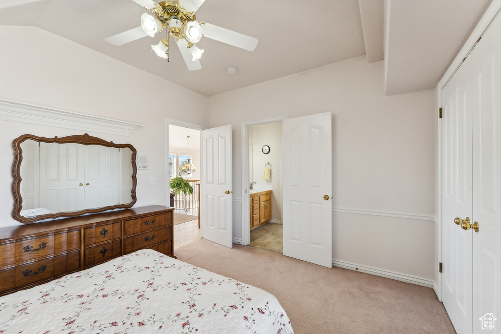 Bedroom with light carpet, ceiling fan, and ensuite bathroom