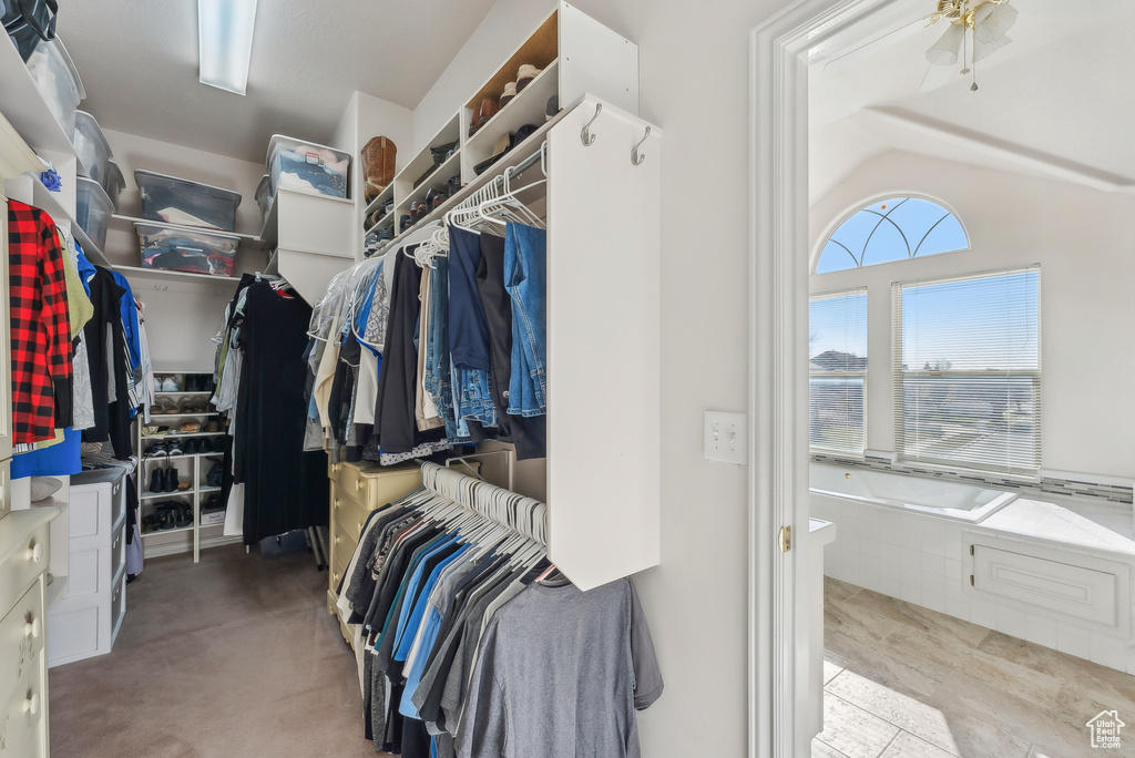 Spacious closet with lofted ceiling and a ceiling fan