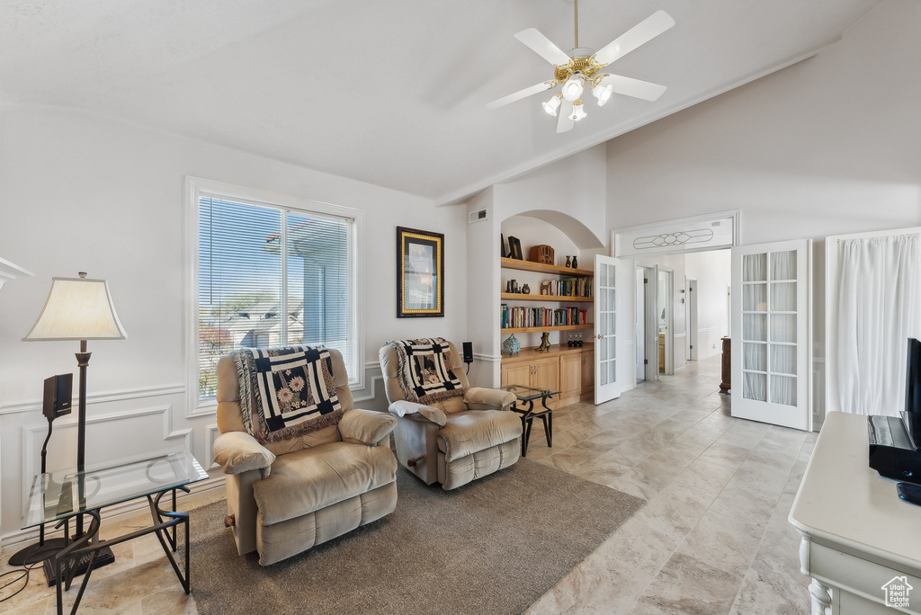 Sitting room with lofted ceiling, ceiling fan, french doors, and built in features