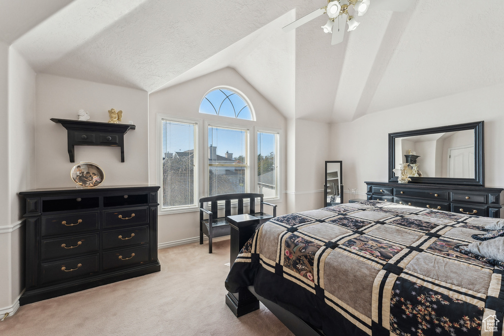 Bedroom with light colored carpet, lofted ceiling, and a ceiling fan