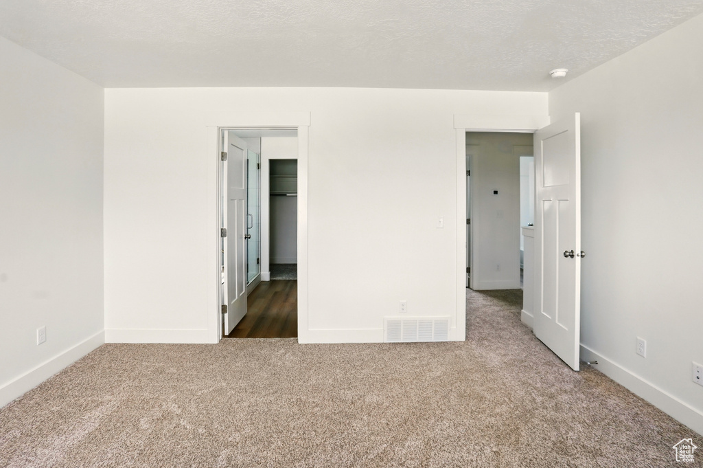 Carpeted spare room featuring baseboards and a smoke detector