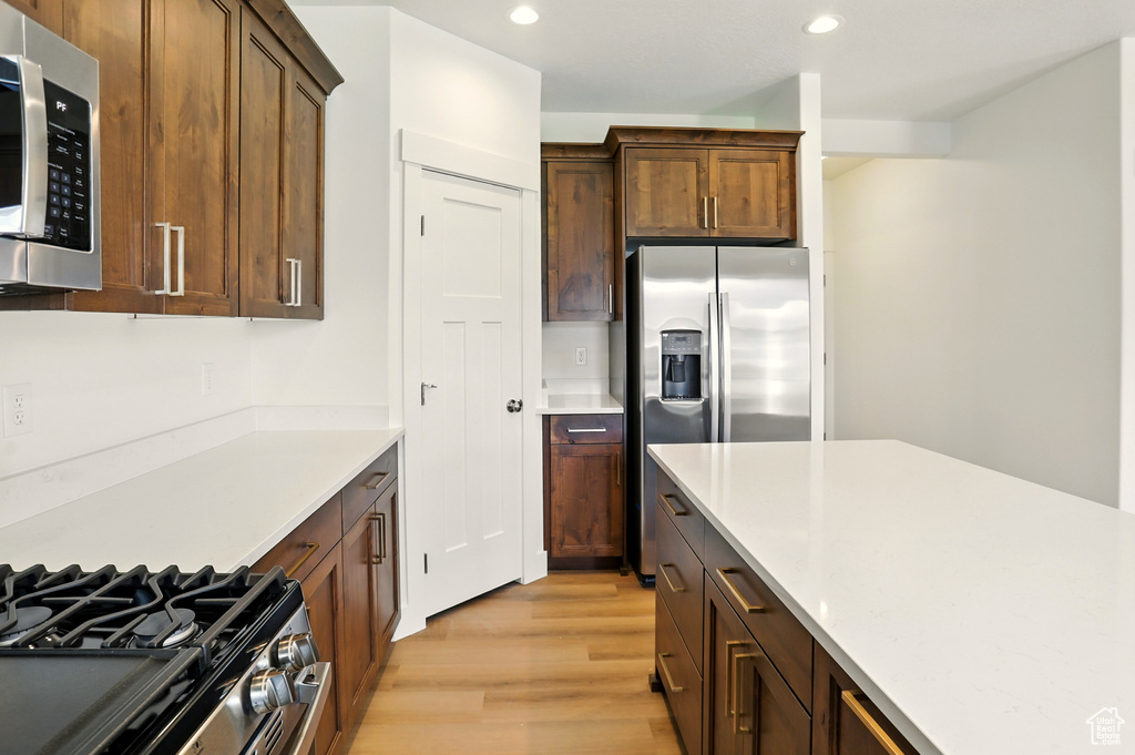 Kitchen featuring appliances with stainless steel finishes, light wood-type flooring, recessed lighting, and light countertops