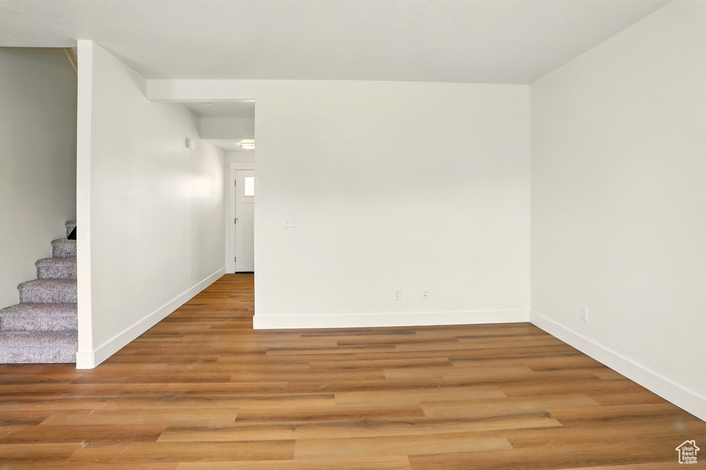 Unfurnished room with stairs and light wood finished floors