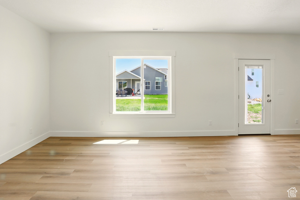 Spare room featuring healthy amount of natural light and light wood-style flooring