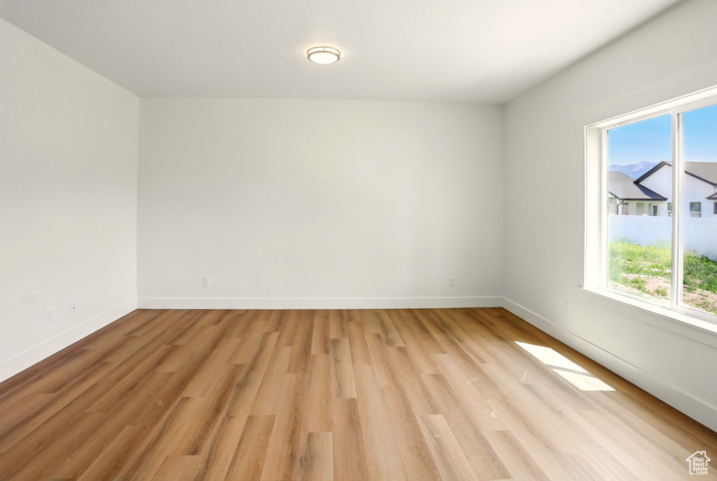 Empty room featuring healthy amount of natural light and light wood finished floors