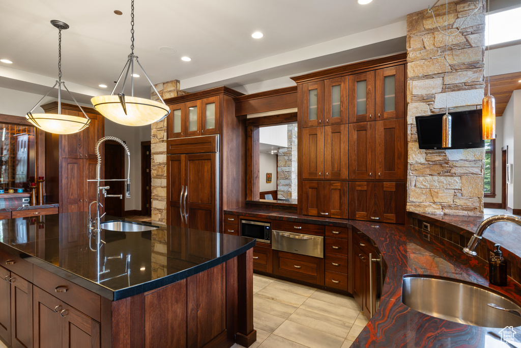 Kitchen featuring a sink, a warming drawer, built in appliances, a kitchen island with sink, and recessed lighting