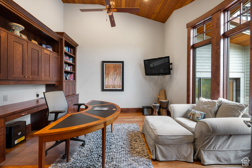Office space with built in desk, a ceiling fan, light wood finished floors, wood ceiling, and baseboards