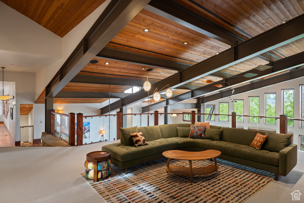 Carpeted living area with wooden ceiling, recessed lighting, and high vaulted ceiling