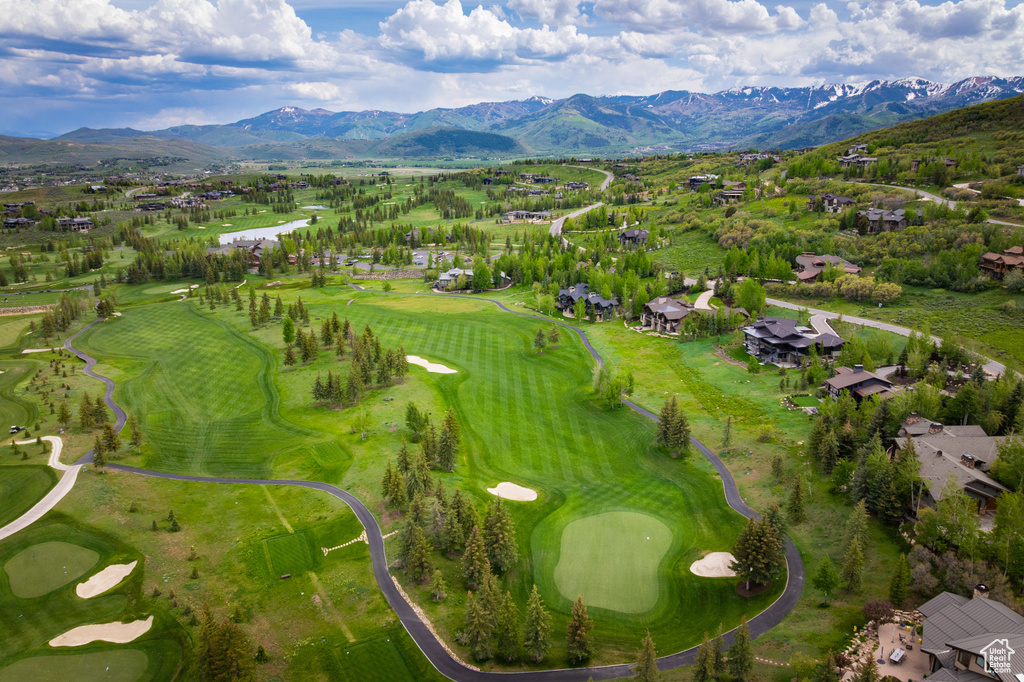 Aerial view of residential area with a mountain backdrop and a golf club