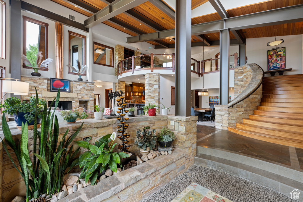 Building lobby featuring a towering ceiling, wood ceiling with exposed beams, and stairway