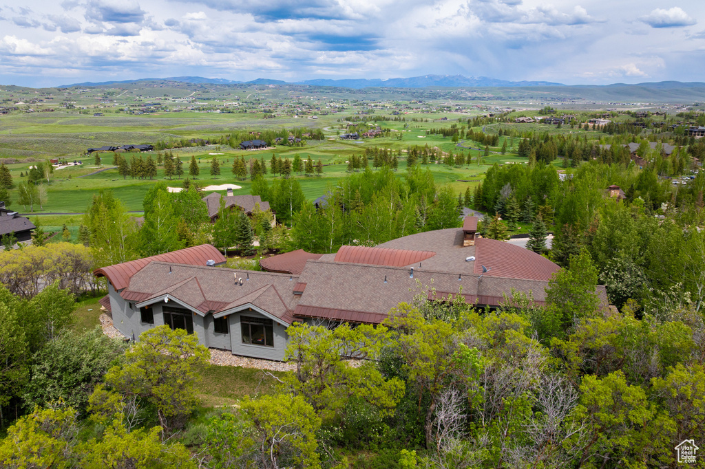 Aerial view of property and surrounding area featuring a mountain backdrop