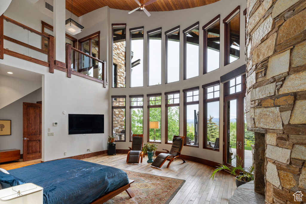 Living room with healthy amount of natural light, high vaulted ceiling, wood-type flooring, baseboards, and wood ceiling