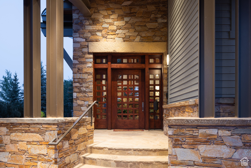 Doorway to property featuring stone siding