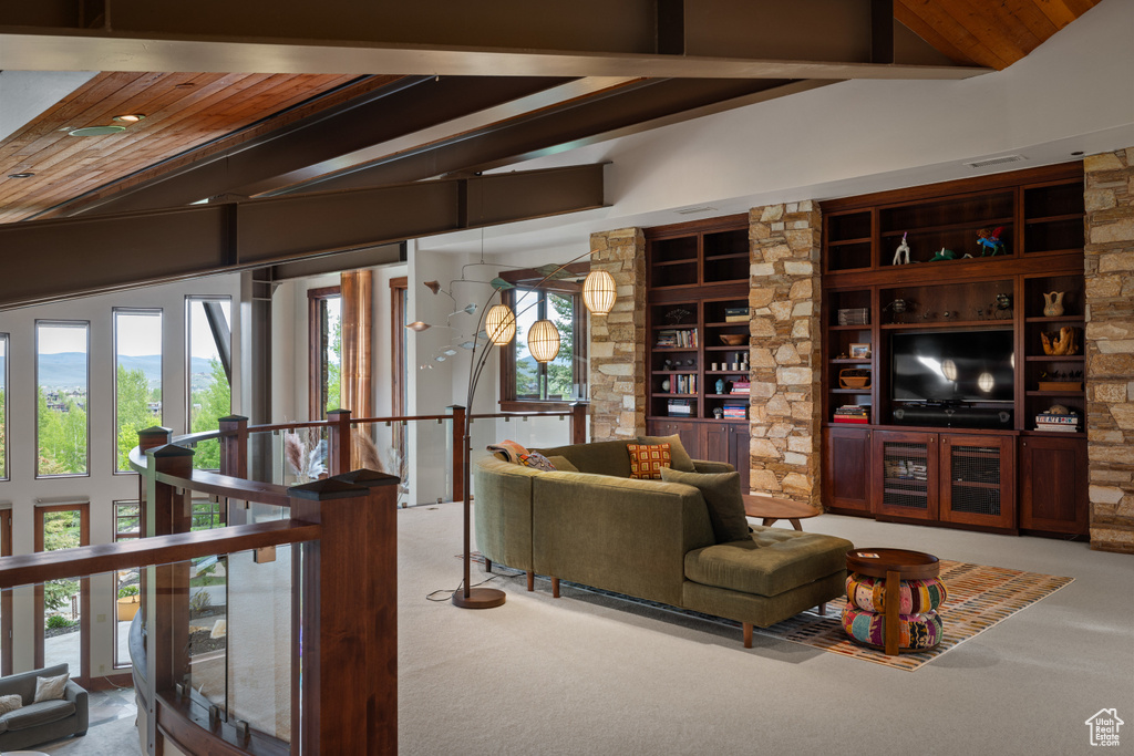 Carpeted living room with beamed ceiling and built in features