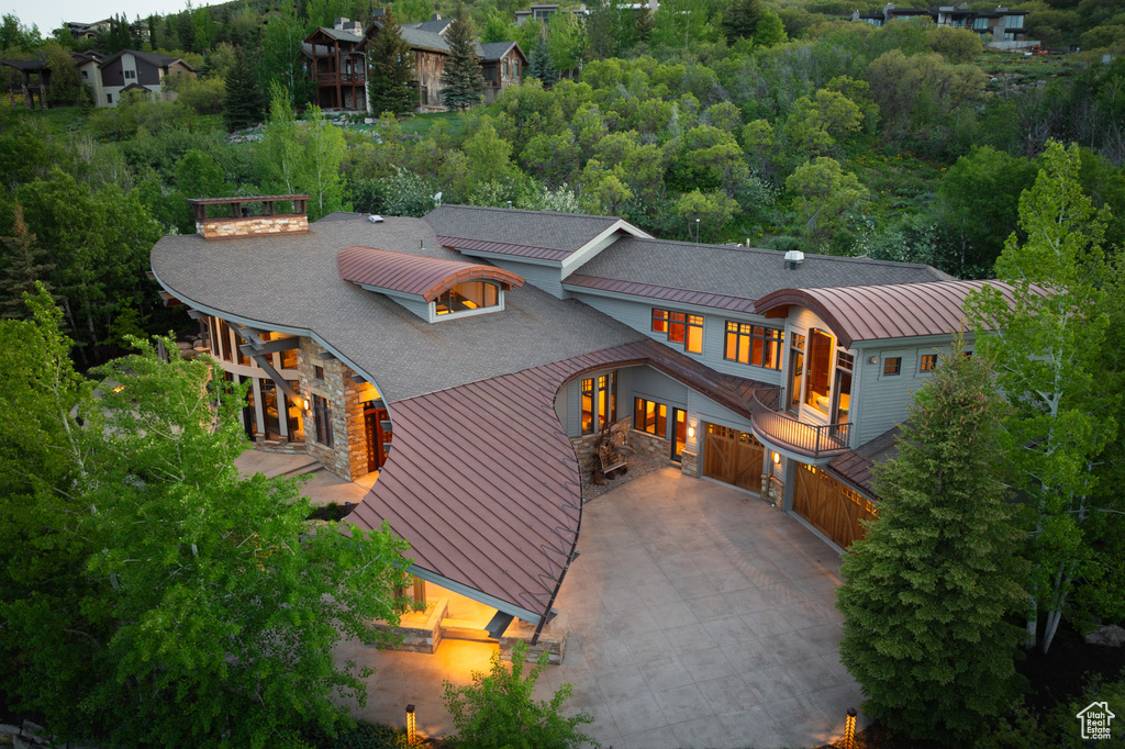 View of front of home with a standing seam roof, driveway, metal roof, and a garage