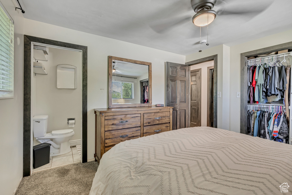 Bedroom with carpet, connected bathroom, a closet, ceiling fan, and tile patterned floors
