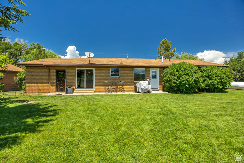 Back of house with brick siding, entry steps, and a patio