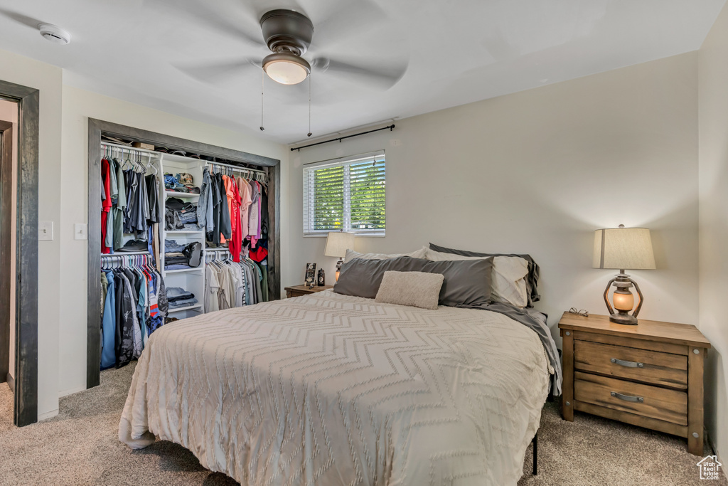 Bedroom with light carpet, a closet, and ceiling fan