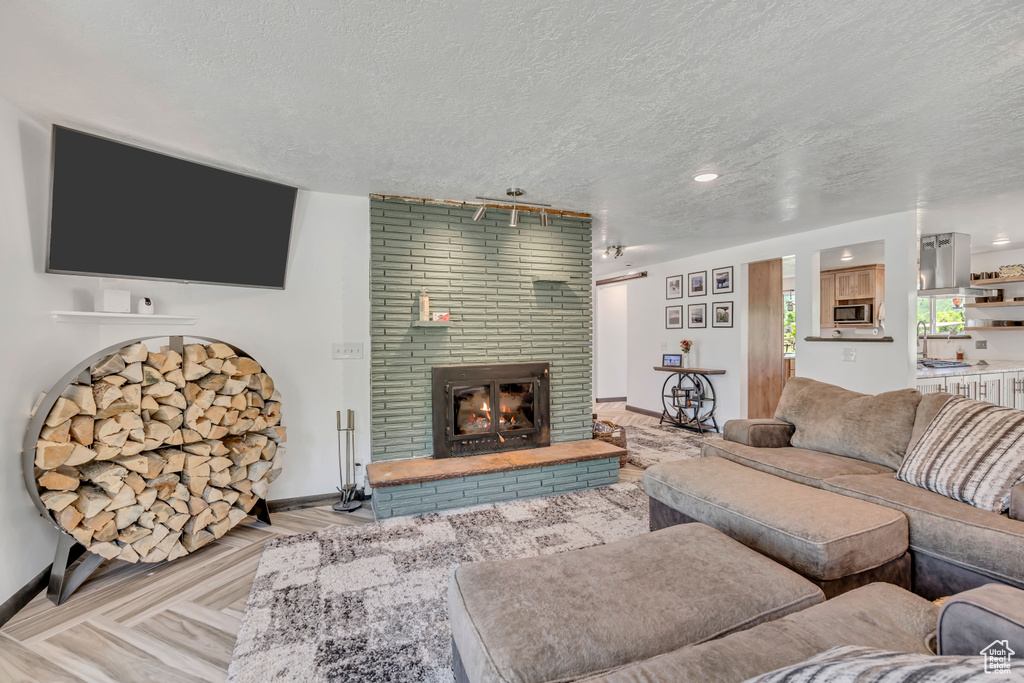 Living room with a textured ceiling and a fireplace