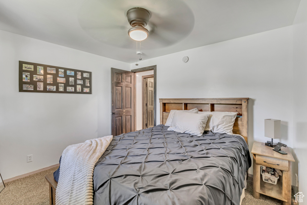 Carpeted bedroom with a ceiling fan and baseboards