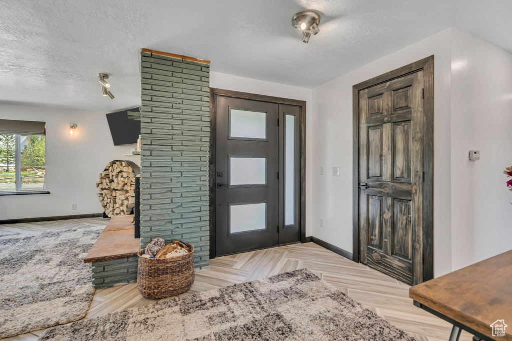 Foyer with a textured ceiling and parquet floors