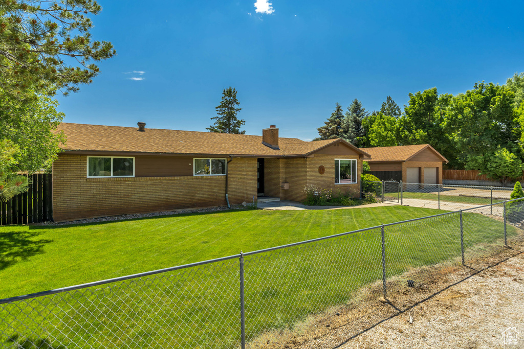 Single story home with brick siding, a chimney, a fenced backyard, and concrete driveway