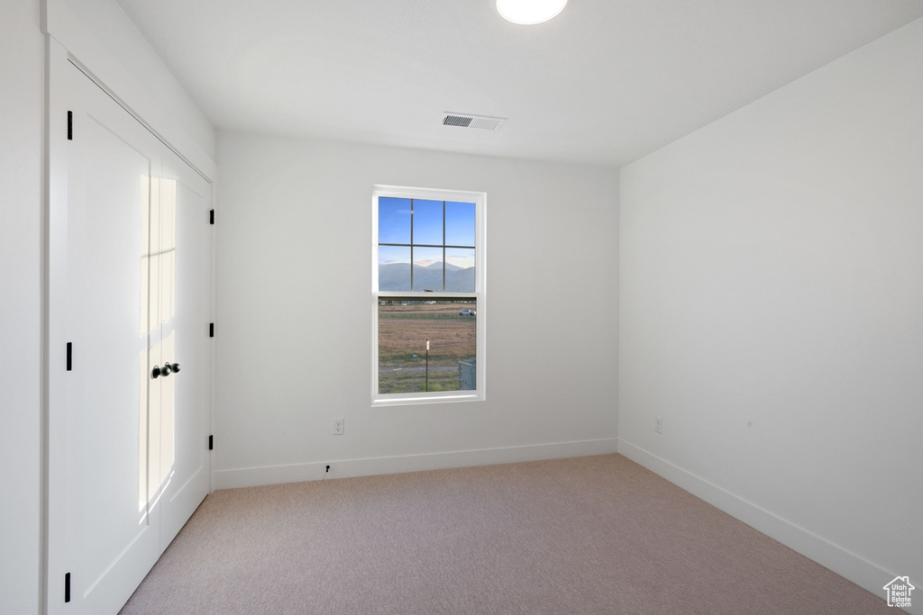 Unfurnished bedroom with light colored carpet