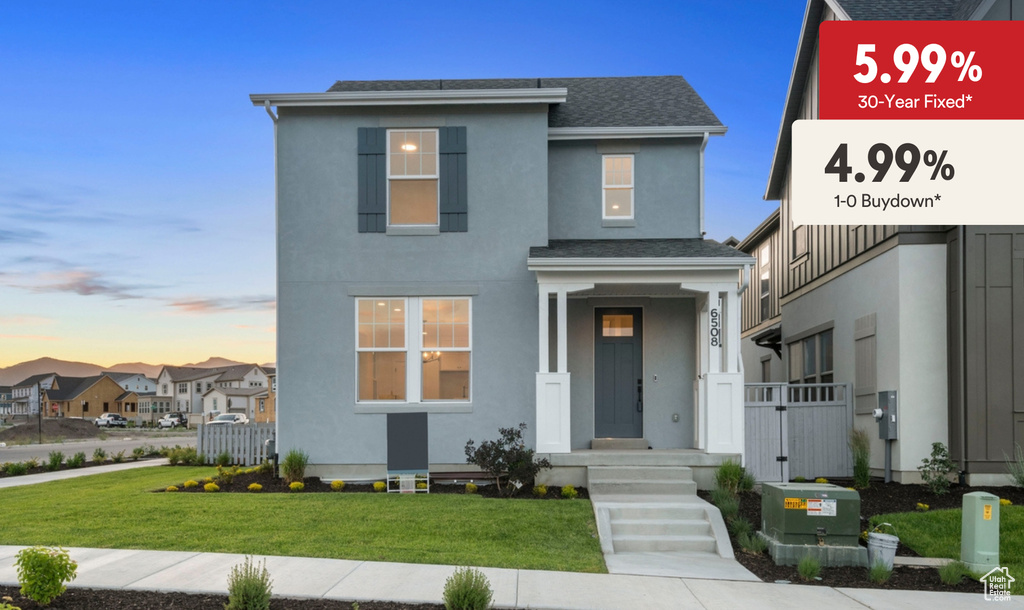 View of front of home featuring stucco siding, a lawn, roof with shingles, and a residential view