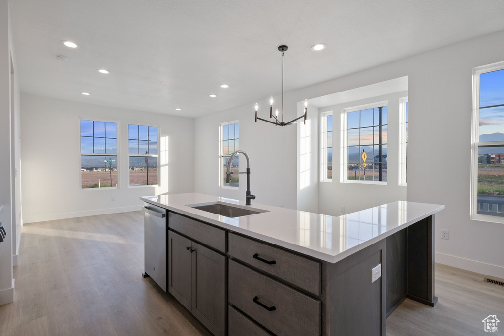 Kitchen featuring light wood-style flooring, a chandelier, light countertops, recessed lighting, and open floor plan
