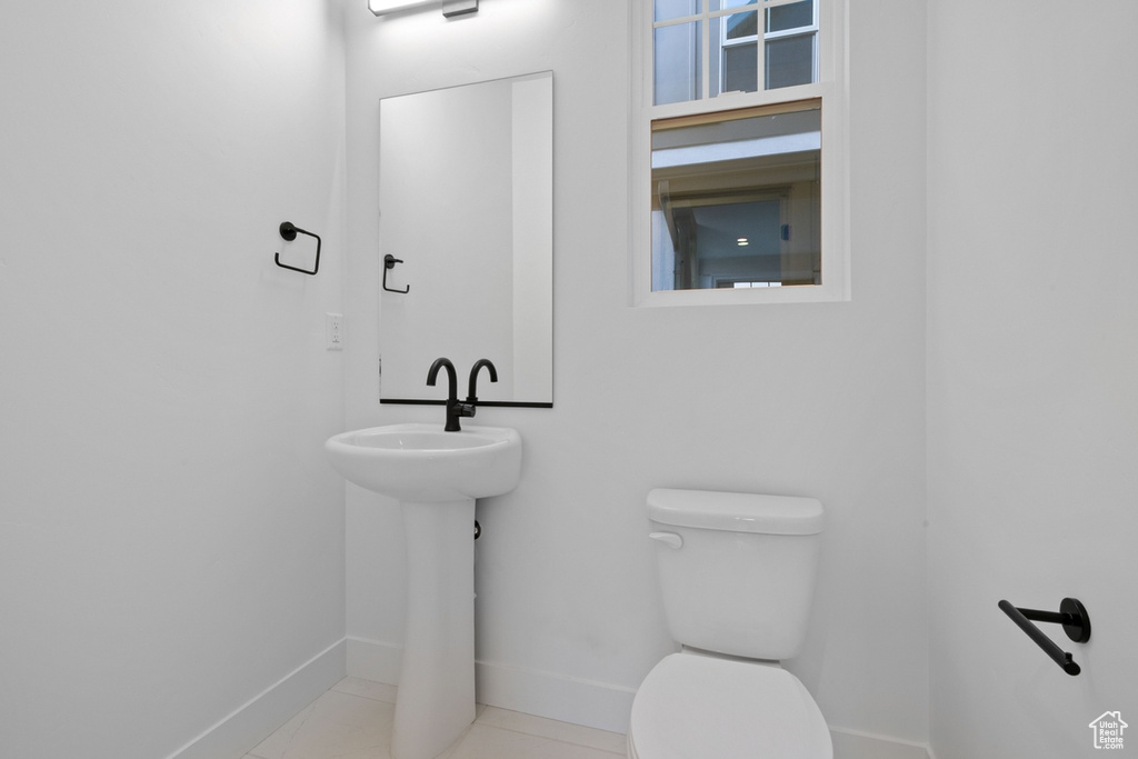 Half bath featuring toilet and baseboards