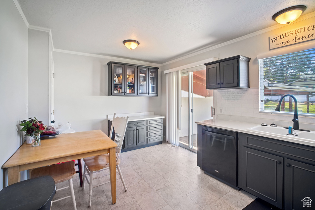 Kitchen featuring dishwasher, a sink, ornamental molding, decorative backsplash, and glass insert cabinets