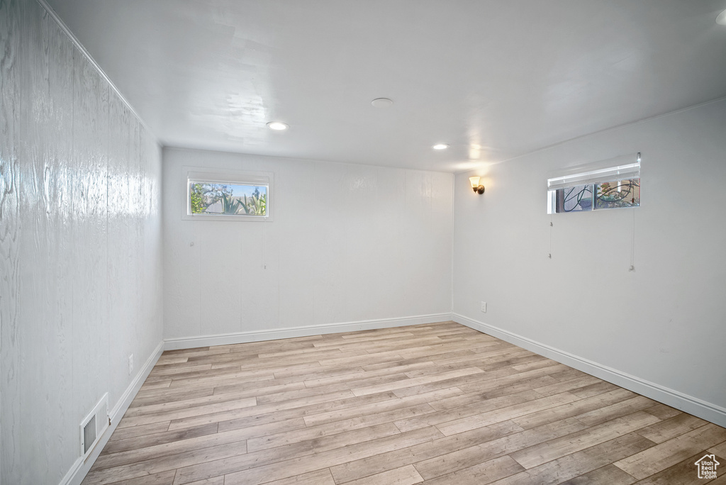 Below grade area with light wood finished floors, recessed lighting, and baseboards